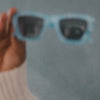 a video of a model wearing blue sunglasses